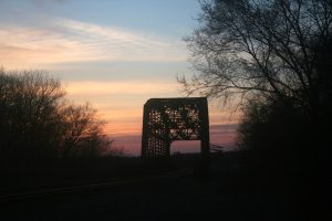 Setting sun over metal bridge