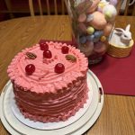 Cherry chip cake with white chocolate, pecans and coconut with pick cherry frosting.