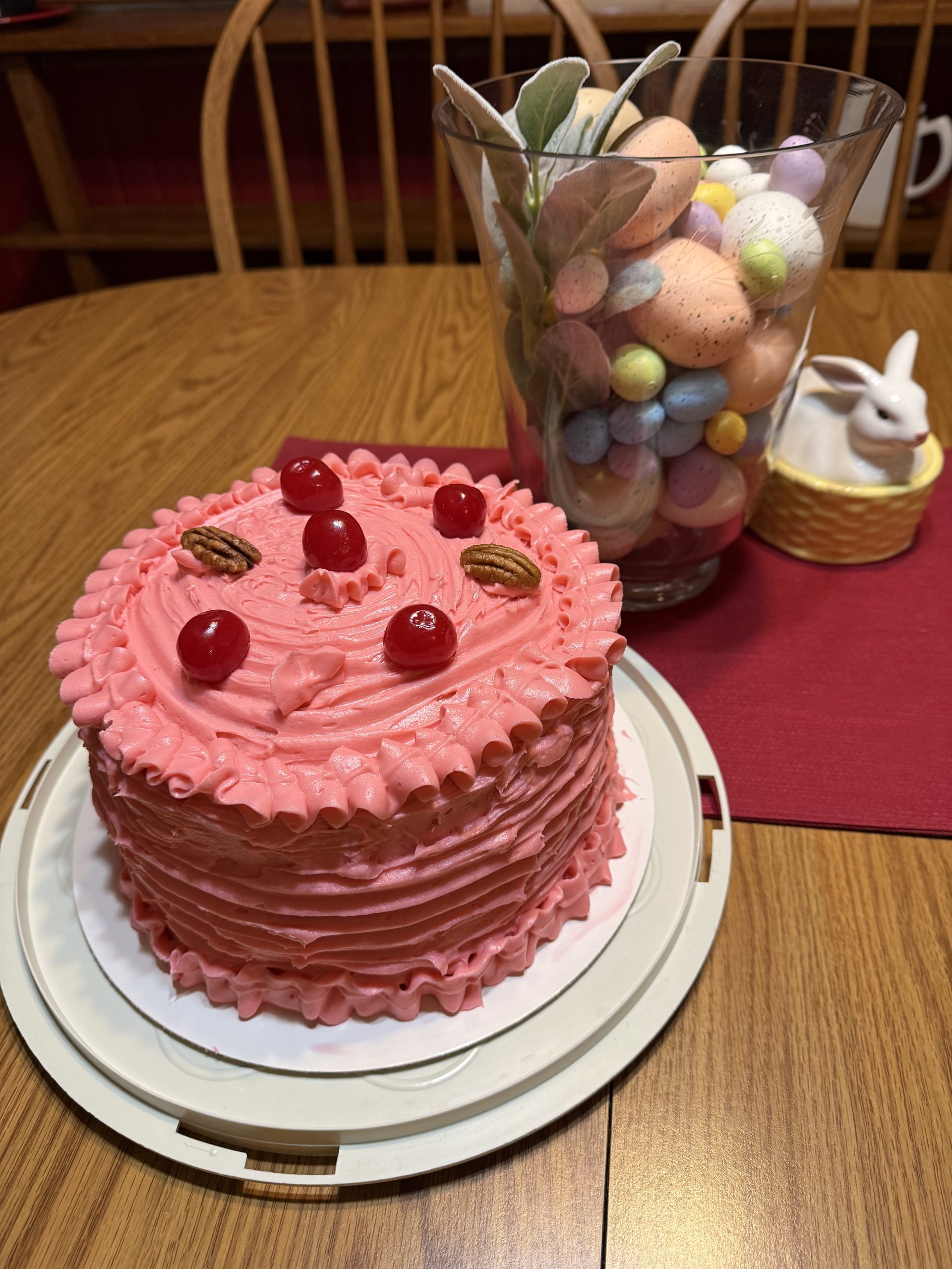Cherry chip cake with white chocolate, pecans and coconut with pick cherry frosting.